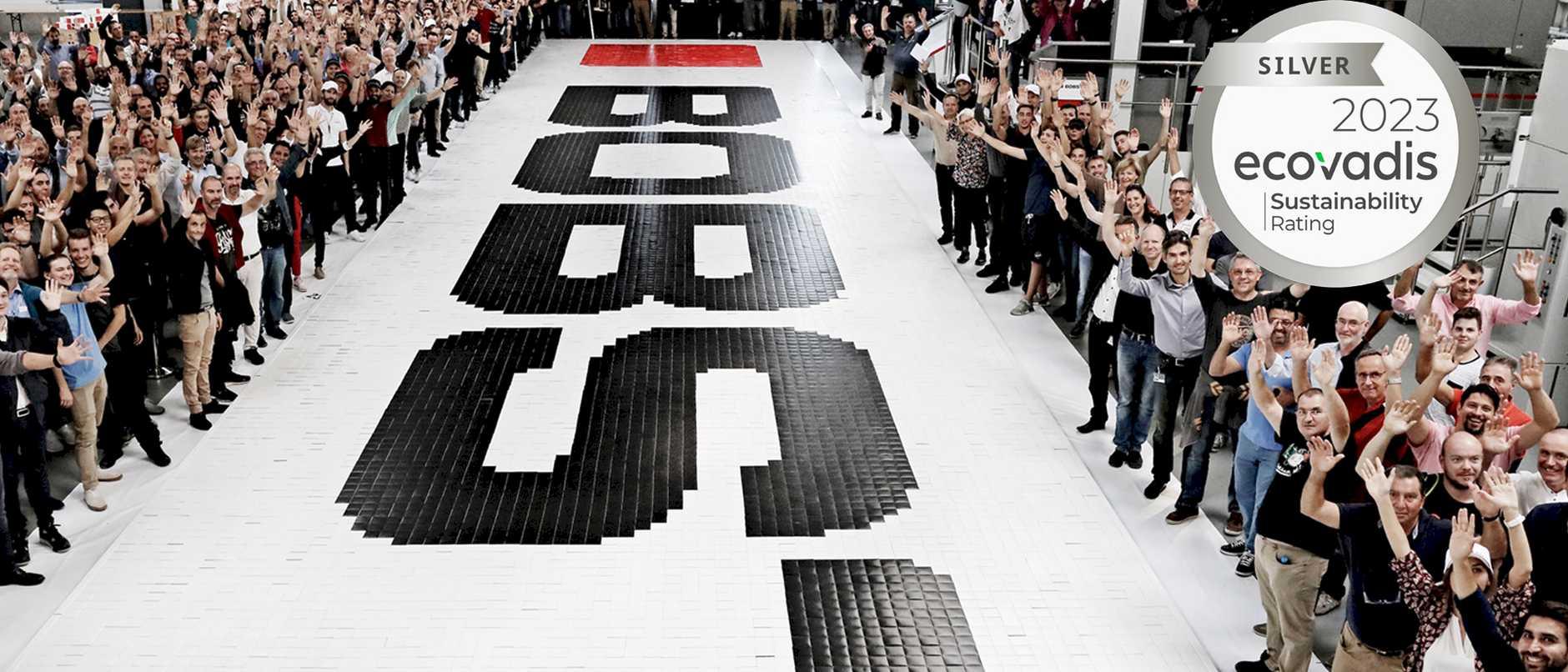 BOBST employees celebrating around a BOBST logo on the floor