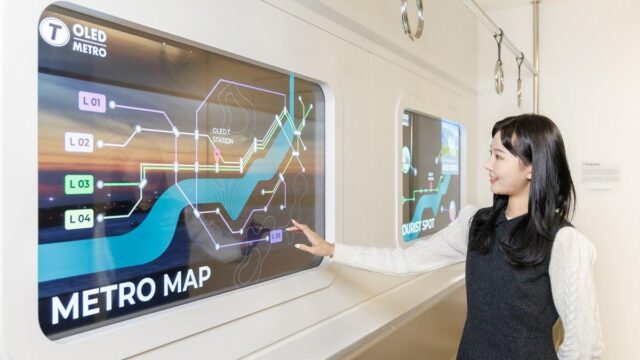 A young woman pointing at a Metro Map displayed on a transparent OLED screen.