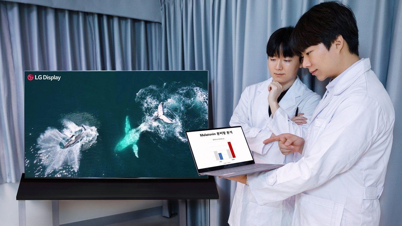 An LG OLED TV and two persons in lab coats