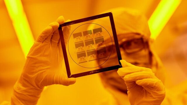 SRI engineer inspects a photomask, a critical component in the microfabrication process used to create semiconductors