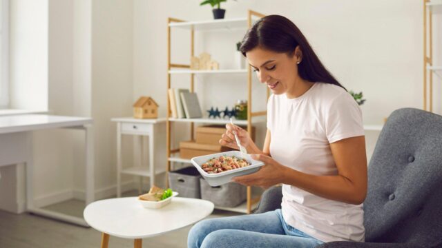 A woman eating out of a tray