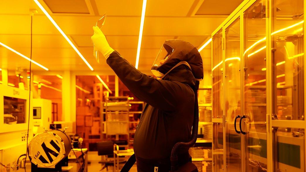 A man holding a CNT device in a cleanroom