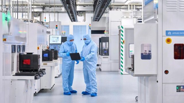 Two lab workers in a cleanroom environment