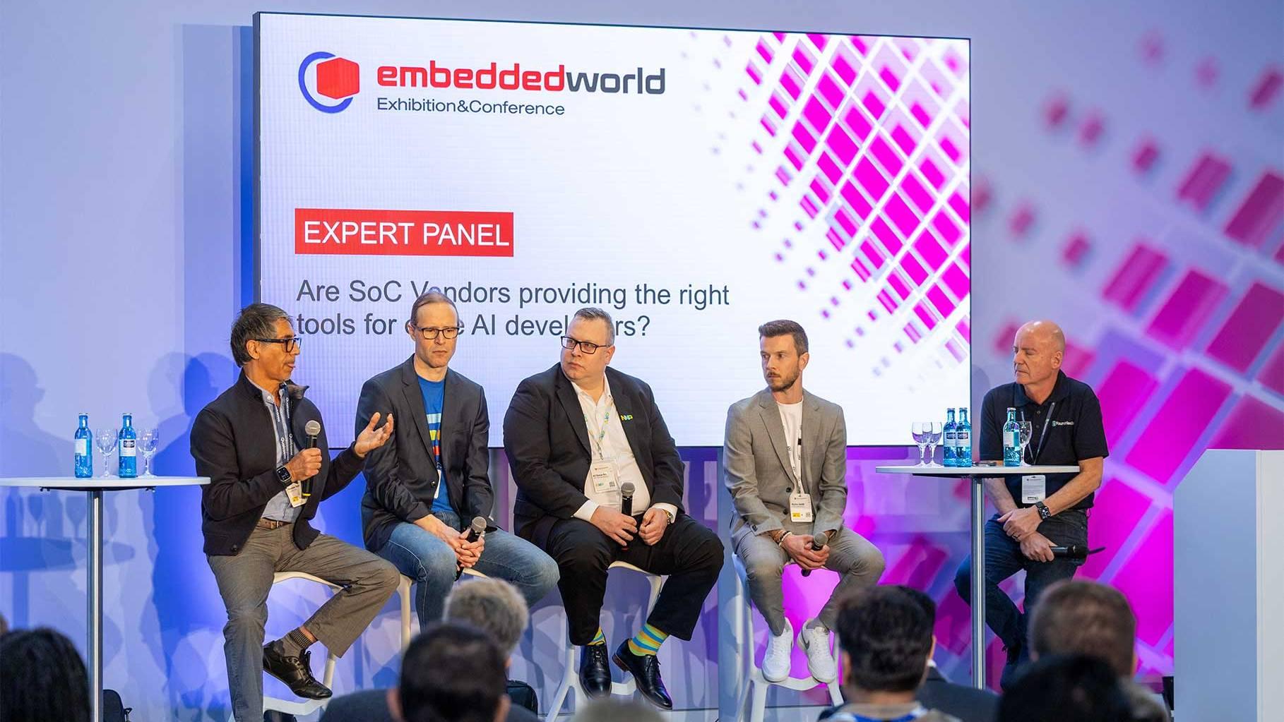 Experts speak on a panel at the embedded world Exhibition&Conference in front of an audience.