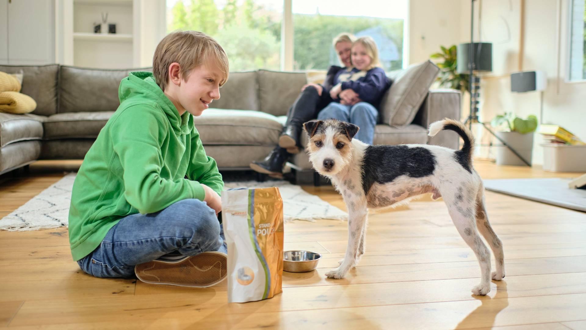 A boy and a dog sitting next to a pouch packaging